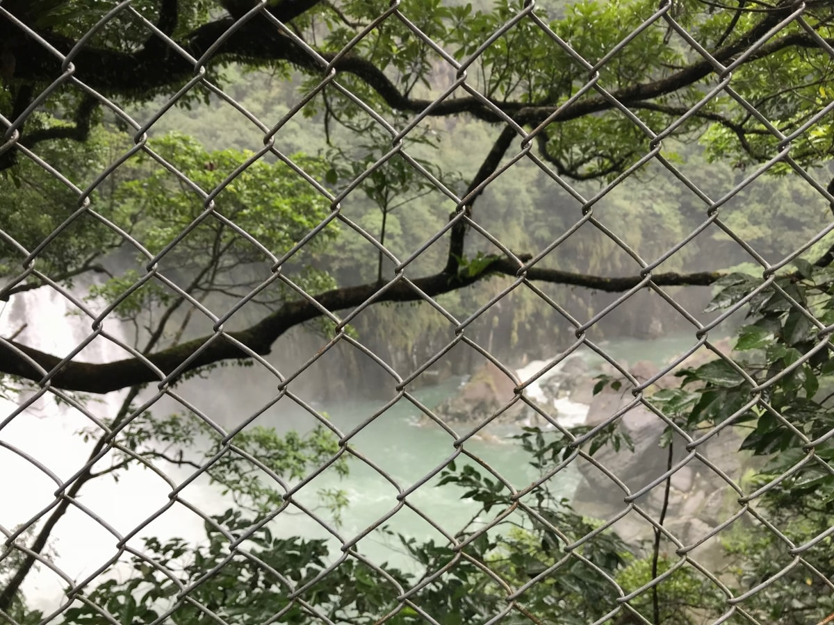 fence in front of waterfall